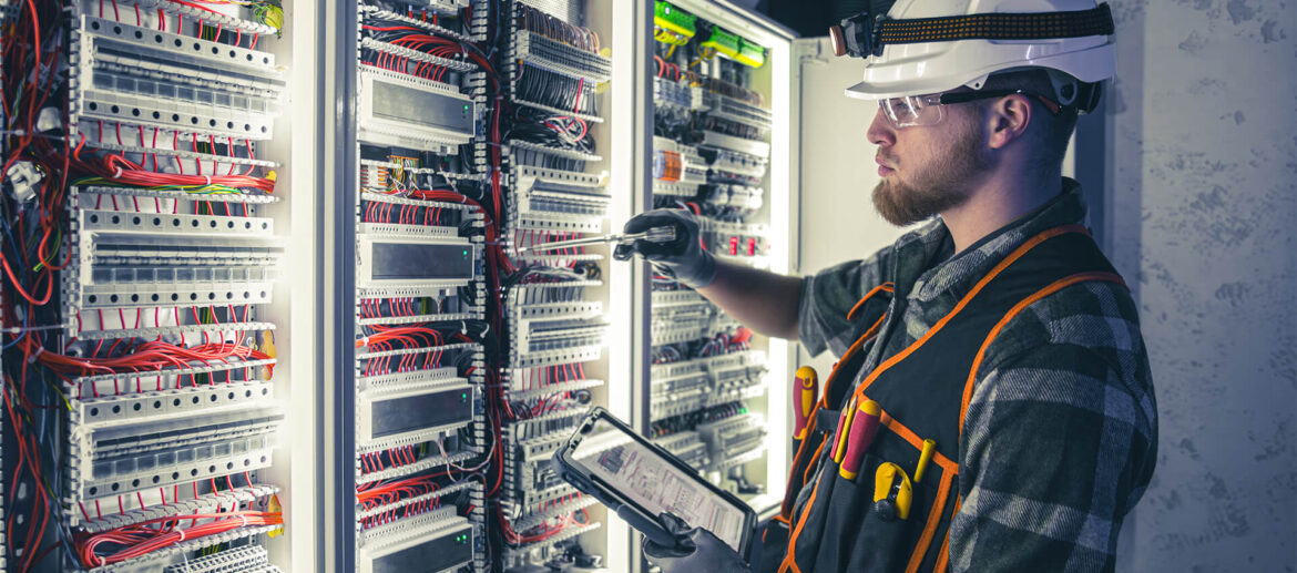electrician-overalls-focused-work-switchboard-with-fuses-using-tablet electrician-overalls-focused-work-switchboard-with-fuses-using-tablet